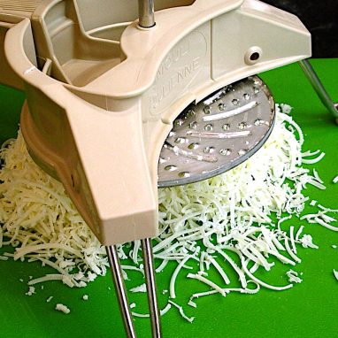 A mouli shown grating Asiago cheese